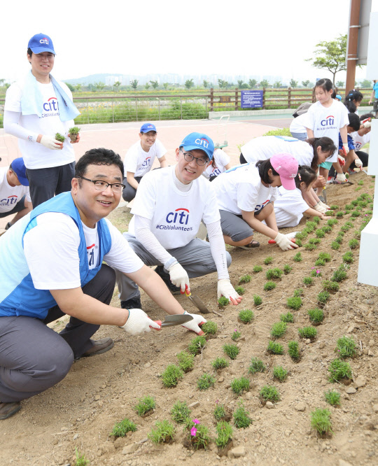 11일 박진회 한국씨티은행장(왼쪽 두 번째)은 씨티은행 임직원들과 함께 경인 아라뱃길의 씨티숲에서 시민 휴식공간 마련을 위해 화초를 심고 있다.  한국씨티은행 제공